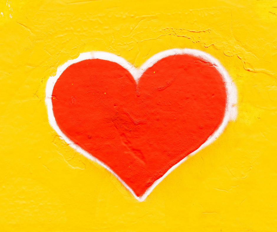 A read painted heart with a white border on a bright yellow background.